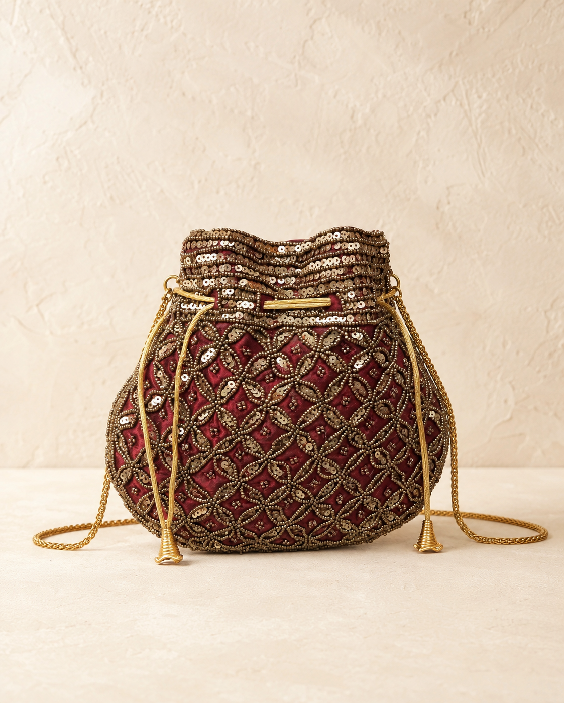 Bolso Saquito Vera. Burdeos, oro envejecido y bronce.