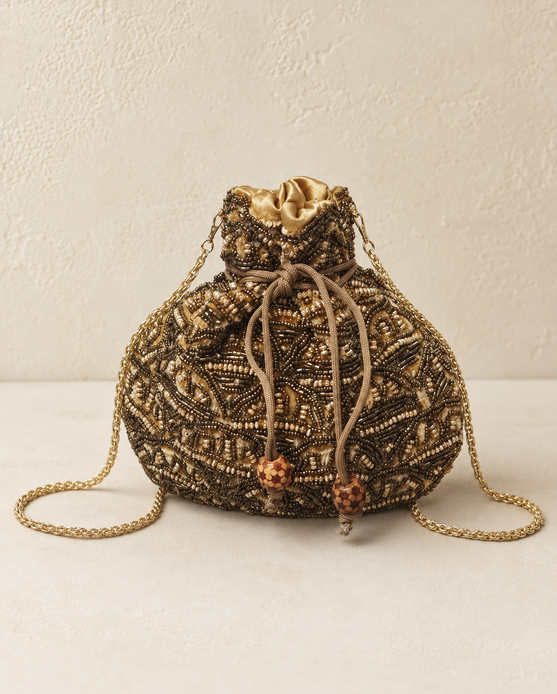 Bolso Saquito Olivia. Oro envejecido, bronce, champán y camel.