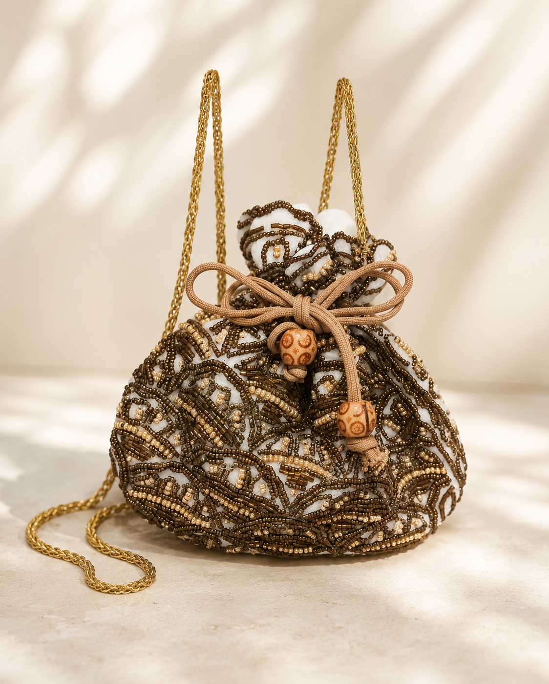 Bolso Saquito Amelia. Blanco roto, dorado envejecido, bronce y beige tostado.