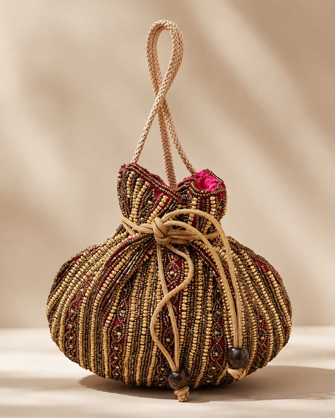Bolso Saquito Renata. Dorado envejecido, bronce, granate, fucsia y beige tostado.