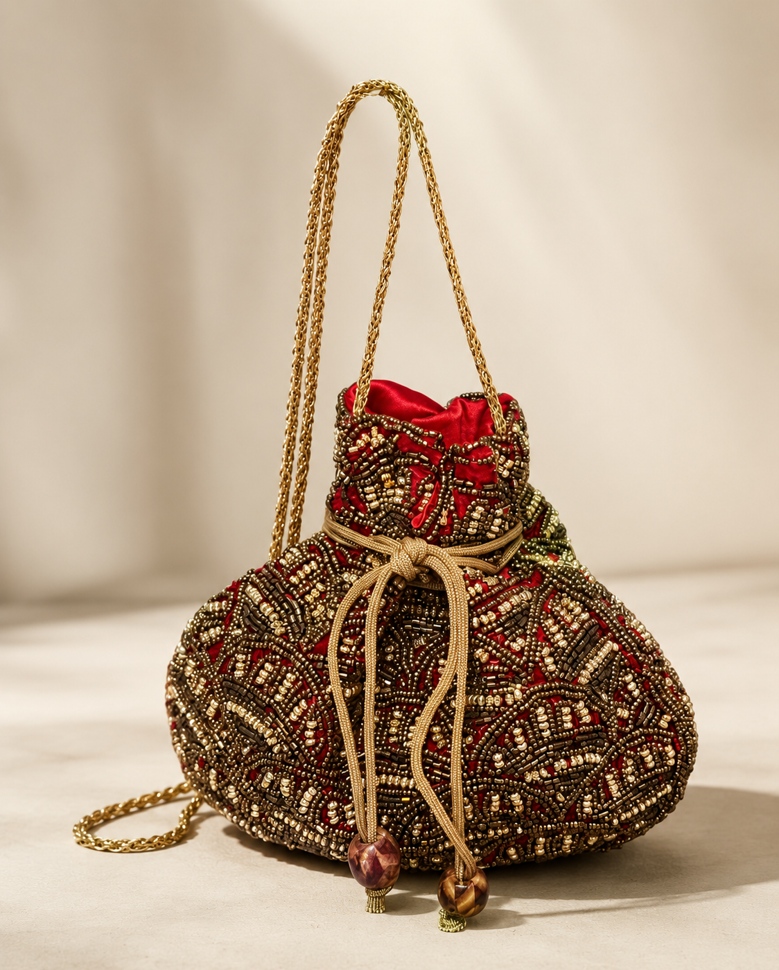 Bolso Saquito Manuela. Rojo intenso, dorado envejecido, bronce, marrón y beige tostado.