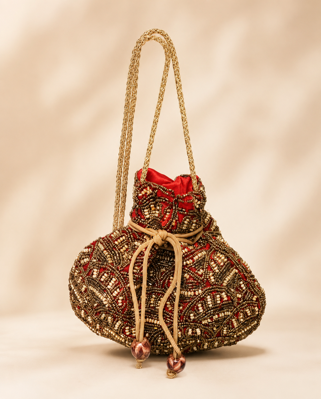Bolso Saquito Carlota. Rojo intenso, dorado envejecido, bronce, marrón y beige tostado.