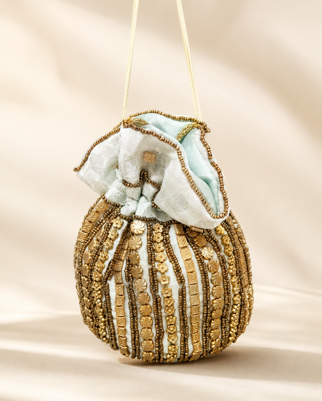 Bolso Saquito Salomé. Verde agua, blanco marfil, dorado envejecido y bronce.